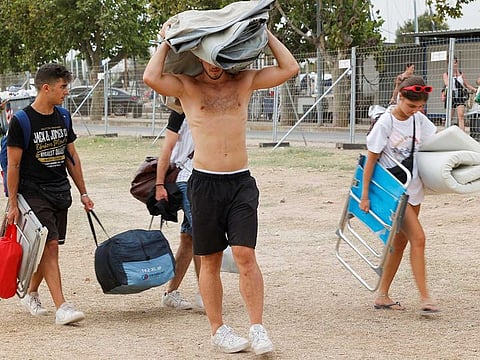 Young people leave the Medusa music festival after high winds caused part of a stage to collapse, in Cullera, near Valencia, Spain, August 13, 2022. 