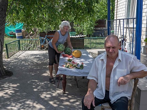 Anastasiya Rudenko, widow of a late Chernobyl "liquidator", prepares watermelon in her garden in Vyschetarasivka, across the river from the Zaporizhzhia atomic power plant, on August 13, 2022. Ukraine remains deeply scarred by the 1986 Chernobyl nuclear catastrophe, when a Soviet-era reactor exploded and streamed radiation into the atmosphere in the country's north. The Zaporizhzhia nuclear power plant in southern Ukraine was occupied in the early days of the war and it has remained in Russian hands ever since. The escalating situation brings dark echoes from the past for those with close links to Chernobyl. Anastasiya’s husband Viktor worked as one of the 600,000 “liquidators”, tasked with painstakingly decontaminating the “Chernobyl exclusion zone,” where high radiation levels forced civilian evacuations.  