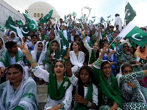 People wave Pakistani flags at the mausoleum of Mohammad Ali Jinnah, founder of Pakistan, to celebrate the Independence Day in Karachi, on August 14, 2022. Millions of Pakistanis celebrate the 76th Independence Day from British rule. 