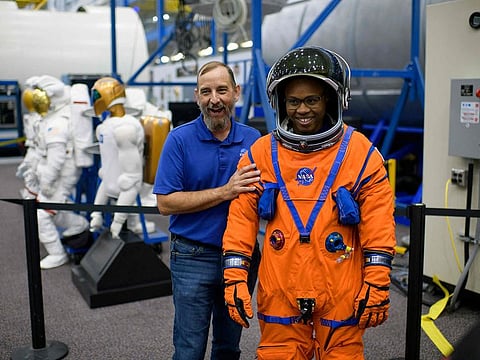 Suit technicians Bill Owens (L) and Henry Phillips laugh while showing off a spacesuit at the Johnson Space Center’s Space Vehicle Mock-up Facility in Houston, Texas