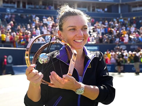 Simona Halep, of Romania, with the trophy after defeating Beatriz Haddad Maia, of Brazil, to win in the final of the National Bank Open tennis tournament in Toronto.