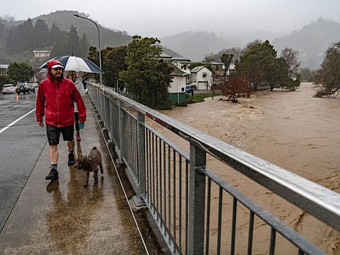 Residents cross a bridge over the Maitai River as severe flooding affects Nelson, New Zealand, August 18, 2022.