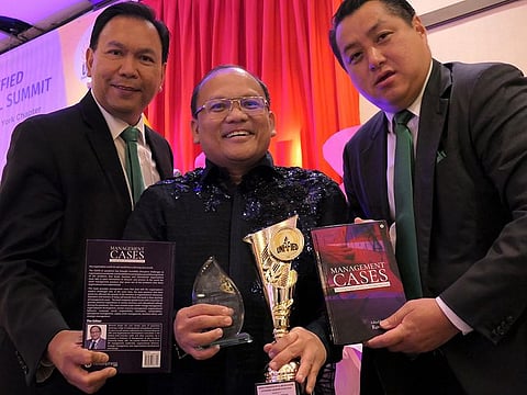 Dr Rommel Sergio (centre) with his award and book in New York