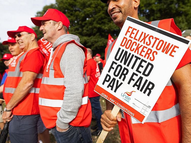 Striking dockers and members of the union hold placards and flags during the first day of a strike at the Port of Felixstowe in Felixstowe, UK, on August 21, 2022. 