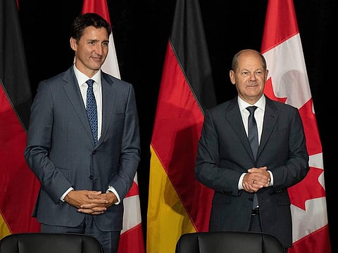 Canadian Prime Minister Justin Trudeau, left, and German Chancellor Olaf Scholz wait for a signing ceremony to begin on Tuesday, Aug. 23, 2022, in Stephenville, Newfoundland and Labrador. 