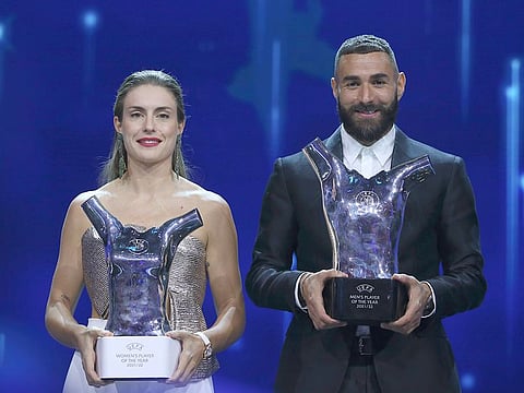 Barcelona's Alexia Putellas, left, and Real Madrid's Karim Benzema, right, hold their trophies as Women's and Men's players of the year during the soccer Champions League draw ceremony in Istanbul, on August 25, 2022. 