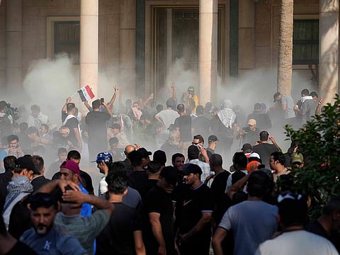 Iraqi security forces fire tear gas on the followers of Shiite cleric Sadr inside the government Palace, Baghdad, on Aug. 29, 2022. 