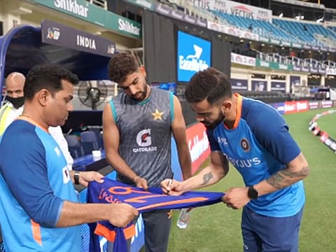 Nice touch... India's Virat Kohli (right) signs a shirt for Pakistan's Haris Rauf.