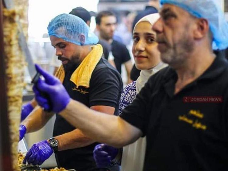 Ruba Tawabini with her father on her left at the shawarma joint in Jordan.