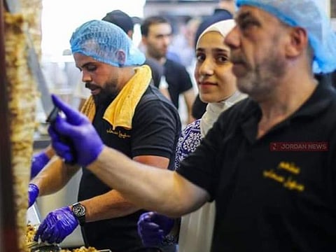 Ruba Tawabini with her father on her left at the shawarma joint in Jordan.