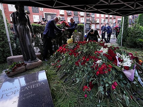 People lay flowers on the grave of former Soviet President Mikhail Gorbachev during his funeral at Novodevichy Cemetery in Moscow, on September 3, 2022.  