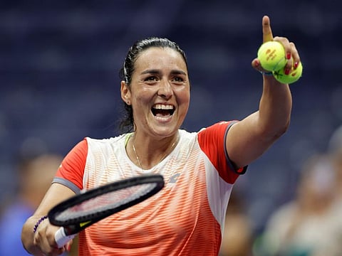 Ons Jabeur, of Tunisia, smiles as she prepares to hit balls to fans in the seating area after winning her match against Veronika Kudermetova, of Russia, during the fourth round of the U.S. Open tennis championships.