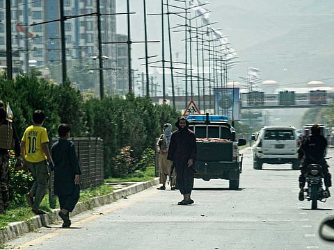 Taliban fighters (C) stand guard along a road near the Russian embassy after a suicide attack in Kabul on September 5, 2022. 