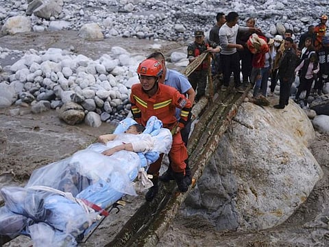 Rescuers transfer survivors across a river following an earthquake in Moxi Town of Luding County, southwest China's Sichuan Province