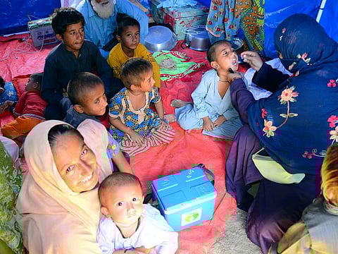 A health worker administers a polio vaccine to a child at a camp in Hyderabad, Pakistan, on September 6, 2022.  
