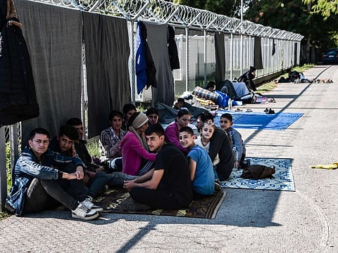 Iraqis wait for the entry into a refugee camp in Serres, northern Greece, on September 6, 2022 as they have been stranded outside the camps in Serres for nearly 2 weeks.  Meanwhile,  A group of 61 migrants picked up by a cargo ship from a crippled fishing boat in the central Mediterranean have safely reached the island of Crete.
