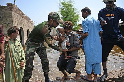 Pakistan's Naval personnel rescue flood-affected people from their damaged houses after heavy monsoon rains in Dadu district, Sindh province, on September 7, 2022.  