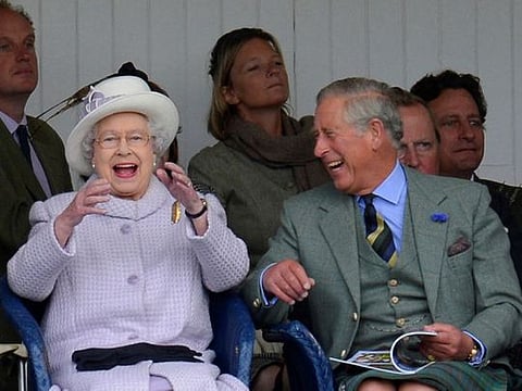 Members of Britain's royal family Queen Elizabeth and Prince Charles cheer as competitors participate in a sack race at the Braemar Gathering in Braemar, Scotland, Britain, September 1, 2012. 