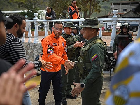 The Mayor of Jauregui municipality Juan Carlos Escalante (2-L), Civil Protection director of Tachira Yesnardo Canal (C) and General Commander of ZODI (Integral Defense Operational Zone) of Tachira Jose Gregorio Martinez, shake hands after their declarations in La Grita town state, Venezuela.