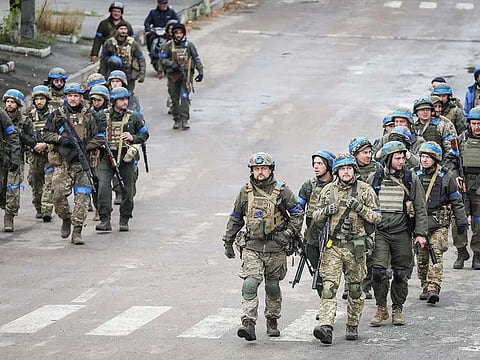 Ukrainian servicemen walk, as Russia's attack on Ukraine continues, in the town of Izium, recently liberated by Ukrainian Armed Forces, in Kharkiv region, Ukraine September 14, 2022. 