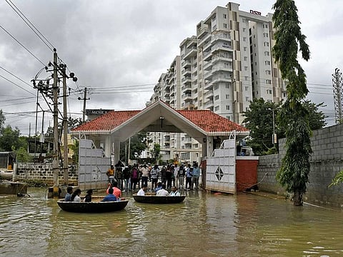 People use Coracle boats to move through a water-logged neighbourhood following torrential rains in Bengaluru, India, September 7, 2022. 