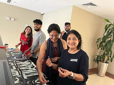 Residents and students of the Greens working on their mosaic art project.