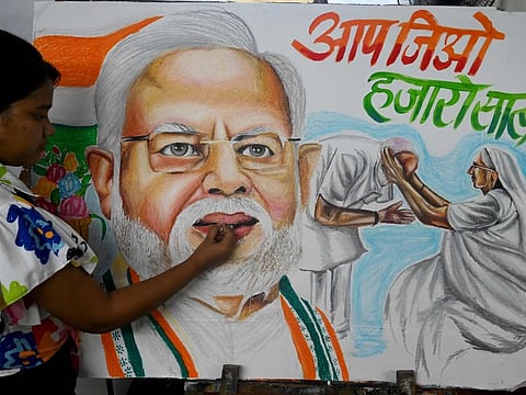 An art school student gives final touches to paintings of Indian Prime Minister Narendra Modi in Mumbai on September 16, 2022. 