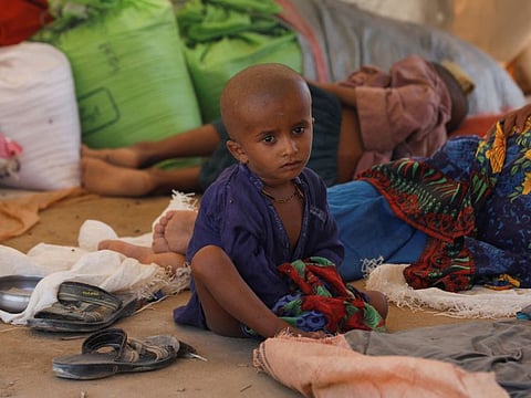 A displaced boy sits as his family takes refuge in a camp in Sehwan, on September 16, 2022. 