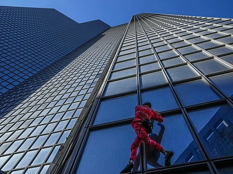 French urban climber Alain Robert, well known as "Spiderman", climbs up the 179-meters (587,27-foot) Total tower at La Defence business district in Paris, on September 17, 2022.  