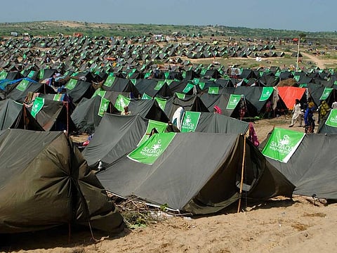 People from flood-affected areas walk between tents in a relief camp, in Chachro near Tharparkar, a district of southern Sindh province, Pakistan, Monday, Sept. 19, 2022.  