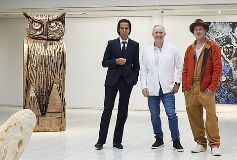 This handout photo taken on September 17, 2022 and received on September 19, 2022 shows British artist Thomas Houseago (centre) posing with US actor Brad Pitt (right) and Australian  musician Nick Cave prior to the opening of the exhibition 'Thomas Houseago - WE with Nick Cave and Brad Bitt' at The Sara Hilden Art Museum in Tampere, Finland.