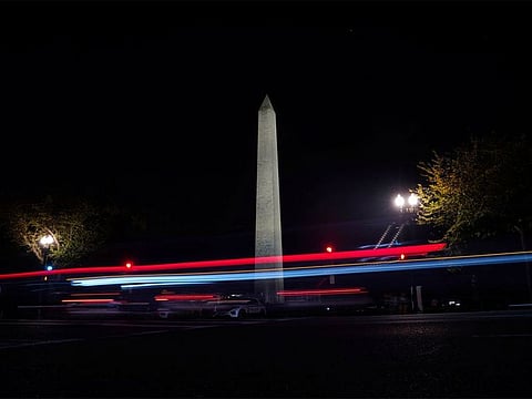 Cars pass by the Washington Monument at night in Washington.