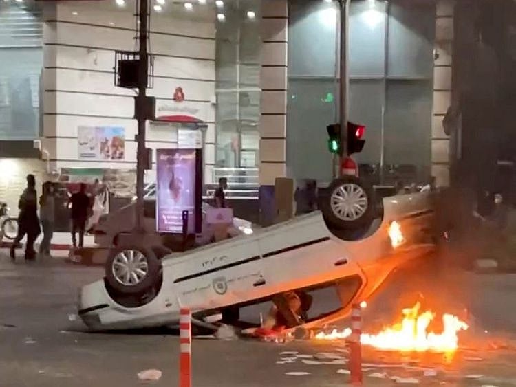 An overturned police car is seen on fire in Bojnurd in Iran on September 22, 2022.