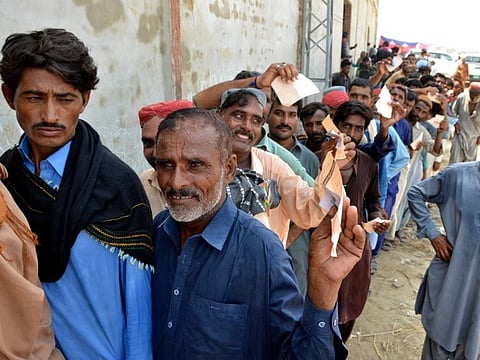 Displaced families line up to get relief aid in Jaffarabad, a district of Balochistan province.