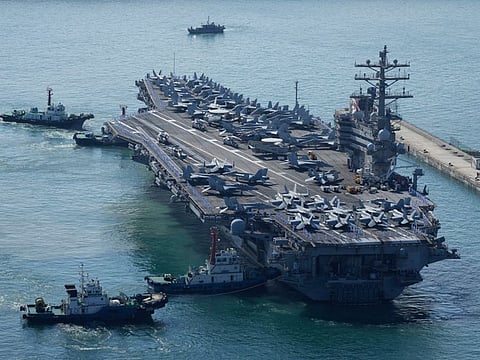 The U.S. carrier USS Ronald Reagan is escorted as it arrives in Busan, South Korea, Friday, Sept. 23, 2022. The nuclear-powered aircraft carrier arrived in Busan port on Friday ahead of the two countries' joint military exercise that aims to show their strength against growing North Korean threats. (AP Photo/Lee Jin-man)