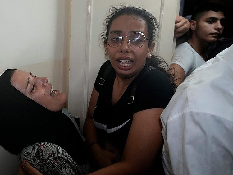 Relatives of two victims who were on a boat carrying migrants from Lebanon that sank in Syrian waters, mourn at their house after they bring back home their bodies, in Tripoli, north Lebanon, September 23, 2022. 