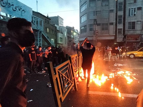 People light a fire during a protest over the death of Mahsa Amini in Tehran.