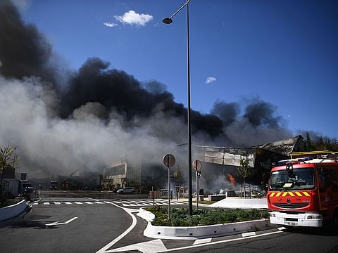 Black smoke billows into the sky as firefighters work to put out a fire in a building at the "Rungis International Market" wholesale food market in Rungis, south of Paris, on September 25, 2022. 