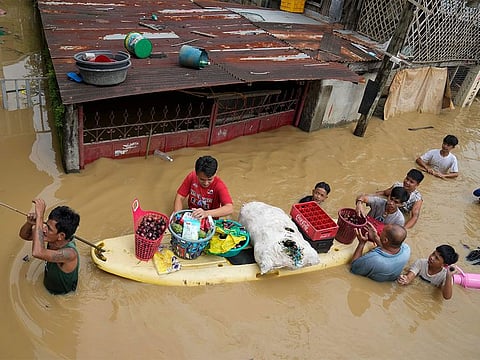 File: Residents give away onions and other foods along a flooded road due to Typhoon Noru (codenamed "Karding" in the Philippines) in San Miguel town, Bulacan. Typhoon Noru blew out of the northern Philippines on Monday, leaving some people dead, causing floods and power outages and forcing officials to suspend classes and government work in the capital and outlying provinces.
