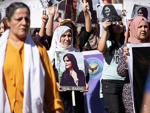 Women carry pictures during a protest over the death of 22-year-old Kurdish woman Mahsa Amini in Iran, in the Kurdish-controlled city of Qamishli, northeastern Syria September 26, 2022. 