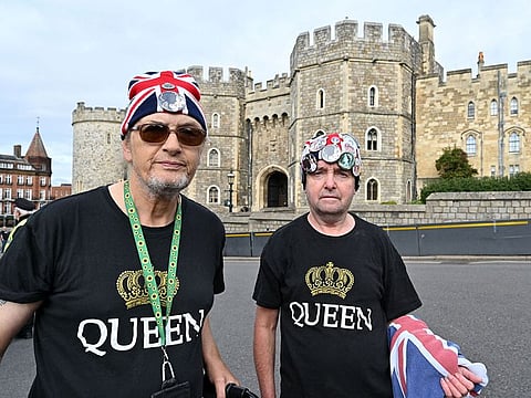 Royal super fans Sky London and John Lowry wearing Union flag-themed hats outside of Windsor Castle in Windsor, west of London on September 29, 2022, as the Castle re-opened to visitors following the death of the Queen. 