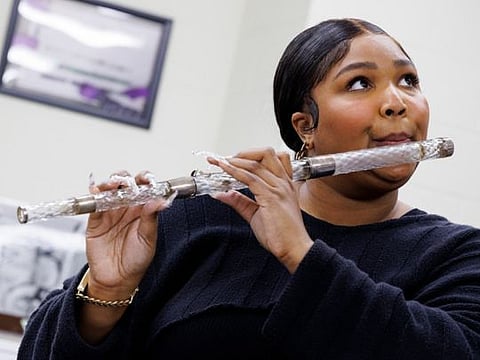Lizzo plays a crystal flute at the Library of Congress.