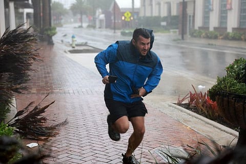 Brent Shaynore runs to a sheltered spot through the wind and rain from Hurricane Ian on September 28, 2022 in Sarasota, Florida.