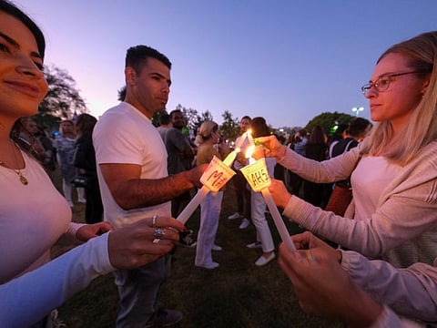 People light candles during a vigil for Mahsa Amini  in Los Angeles, California on September 29, 2022.  