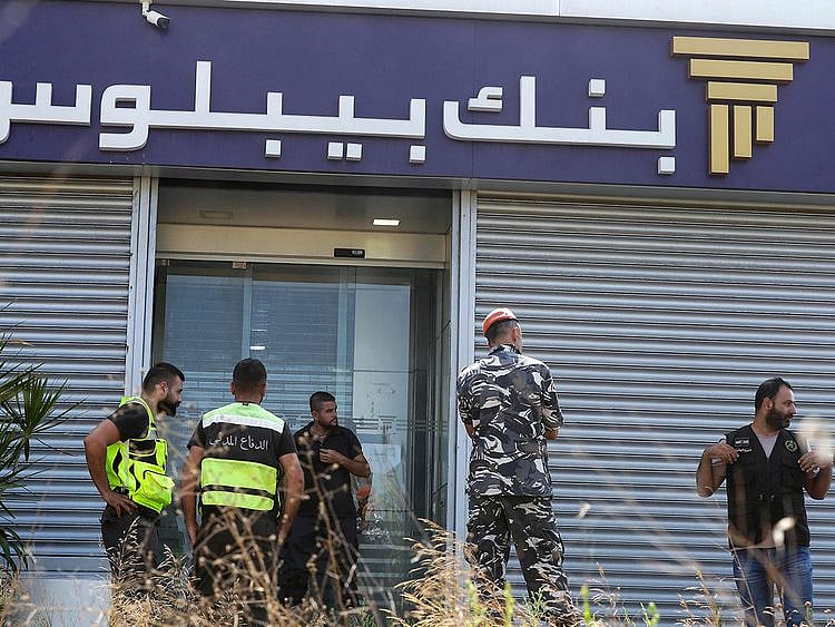 Members of Lebanon's security forces and emergency services deploy at a bank branch held-up by an angry depositor demanding access to his savings, in the southern city of Tyre, on Octobre 4, 2022.  