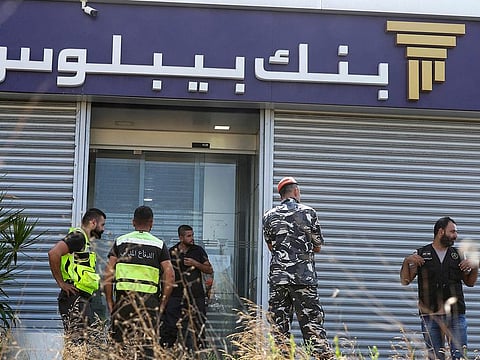 Members of Lebanon's security forces and emergency services deploy at a bank branch held-up by an angry depositor demanding access to his savings, in the southern city of Tyre, on Octobre 4, 2022.  