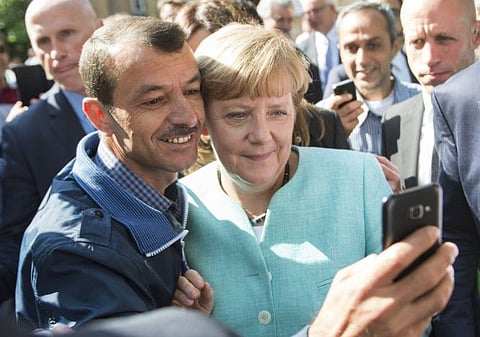 In this Sept. 9, 2015 file photo German chancellor Angela Merkel poses for a selfie with a refugee in a facility for arriving refugees in Berlin.