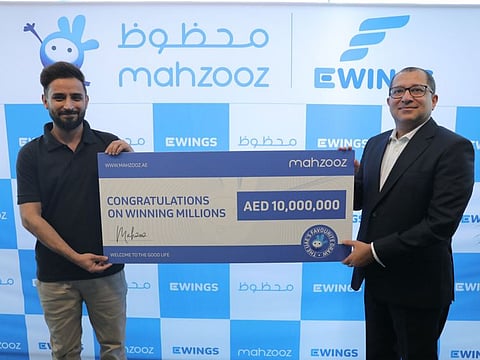 Saad, 32, left, receiving the cheque from  Farid Samji, CEO of Ewings.