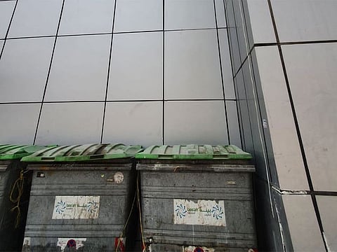 The garbage bins below the building from which the woman tried to jump.  