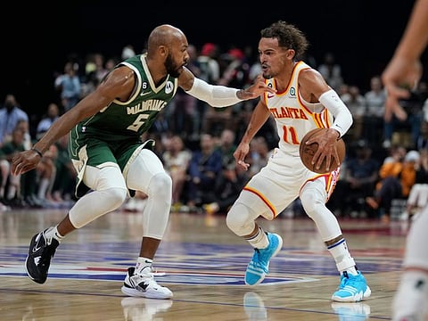 Trae Young (right) of Atlanta Hawks dribbles in from to Jevon Carter of Milwaukee Bucks during a preseason NBA basketball game in Abu Dhabi, United Arab Emirates.